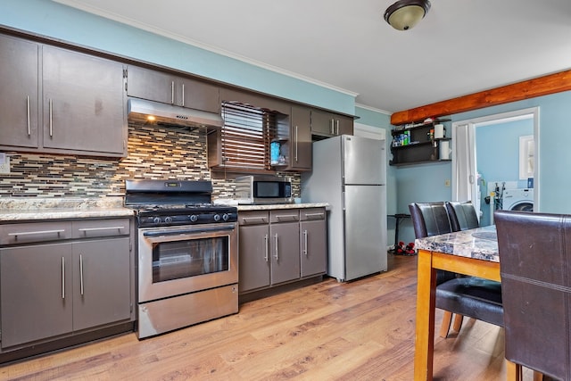 kitchen featuring gray cabinets, decorative backsplash, appliances with stainless steel finishes, light hardwood / wood-style flooring, and washer / clothes dryer