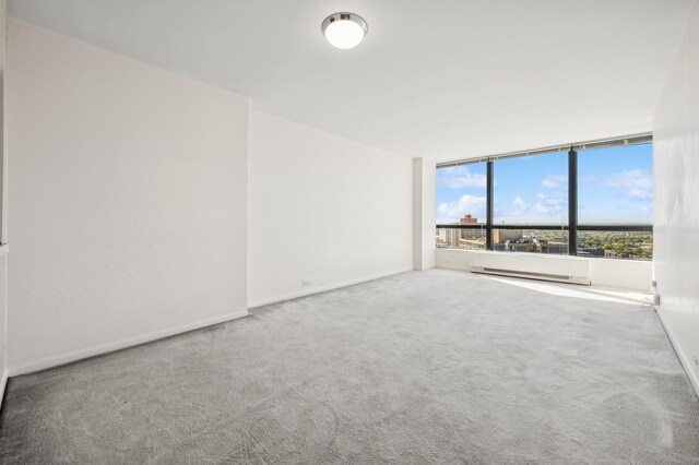 unfurnished room with baseboards, a baseboard radiator, and carpet flooring