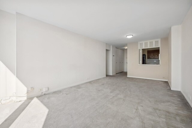 unfurnished room featuring carpet floors and baseboards