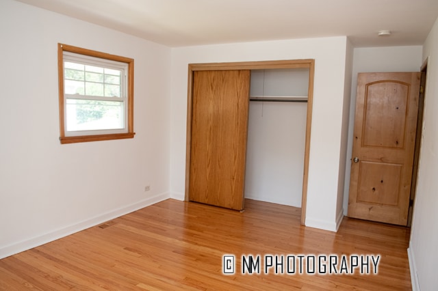 unfurnished bedroom featuring light hardwood / wood-style floors and a closet