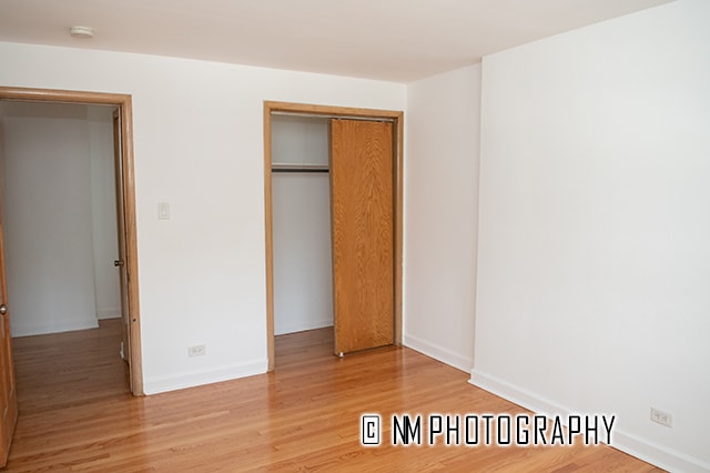 unfurnished bedroom featuring light hardwood / wood-style flooring and a closet