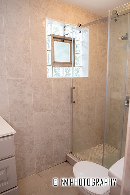 bathroom featuring vanity, tile walls, an enclosed shower, toilet, and tile patterned flooring