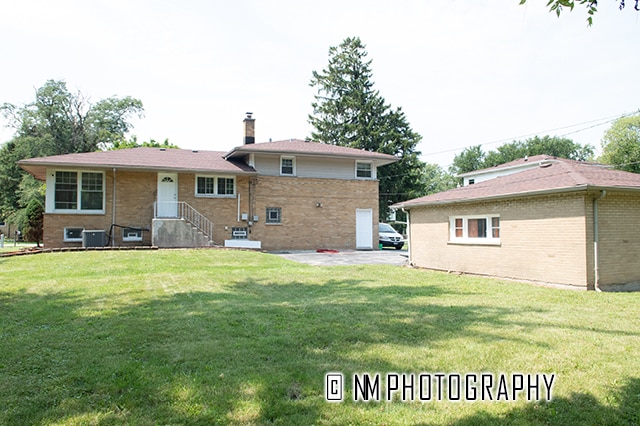 rear view of property with a yard