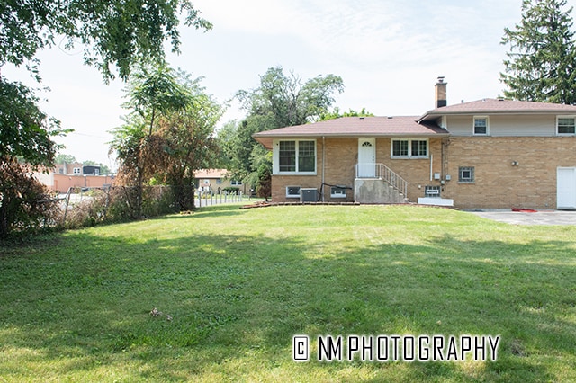 back of house featuring a lawn