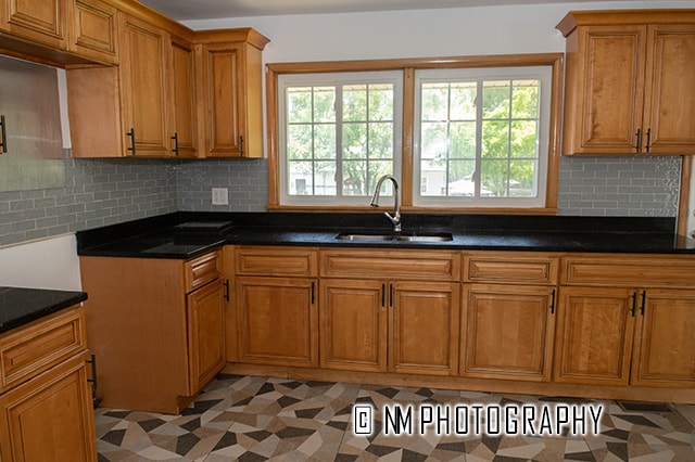 kitchen featuring sink, dark stone countertops, light tile patterned floors, and backsplash