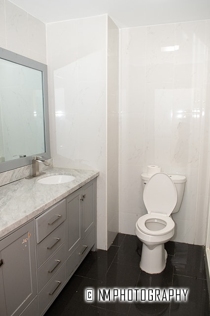 bathroom with vanity, tile patterned floors, toilet, and tile walls