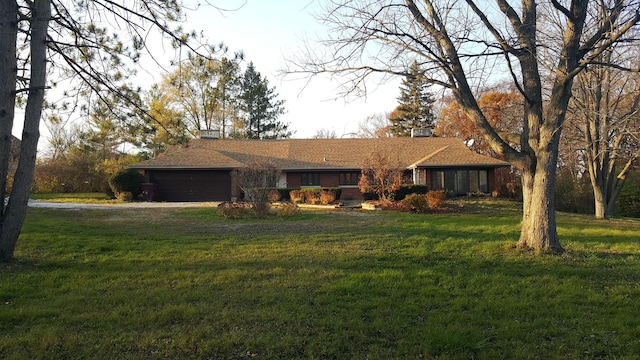 ranch-style home with dirt driveway, a front yard, and a garage