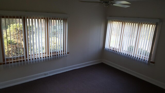 carpeted spare room featuring ceiling fan and plenty of natural light