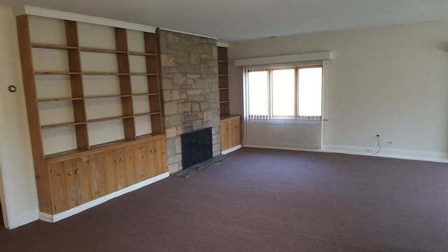 unfurnished living room with a fireplace and dark carpet