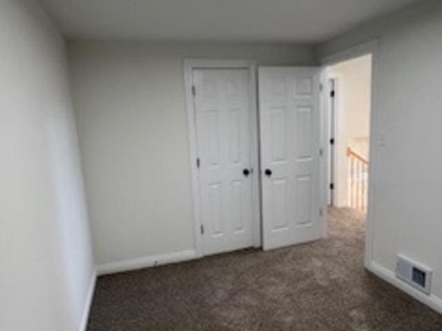 unfurnished bedroom featuring dark colored carpet