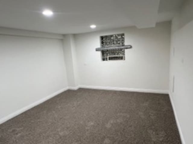 basement featuring dark carpet