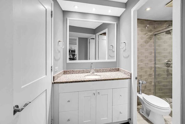 bathroom featuring vanity, toilet, tile patterned flooring, and walk in shower