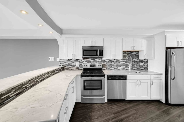 kitchen featuring decorative backsplash, appliances with stainless steel finishes, dark wood-type flooring, and white cabinetry