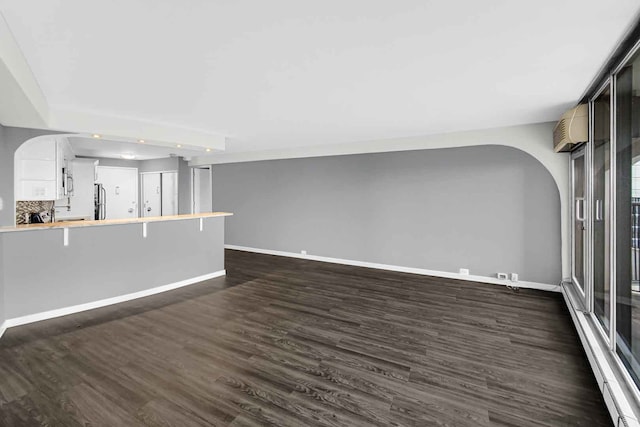 unfurnished living room featuring dark hardwood / wood-style floors and baseboard heating