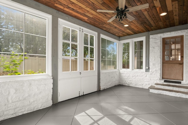 unfurnished sunroom featuring ceiling fan and wood ceiling