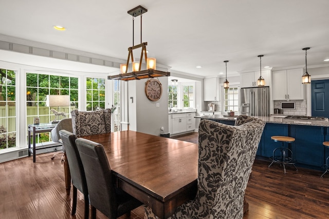 dining room with dark wood-type flooring and crown molding