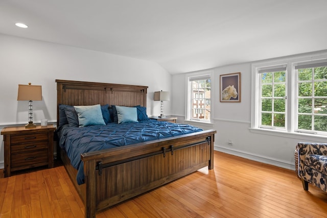 bedroom featuring lofted ceiling and light hardwood / wood-style floors