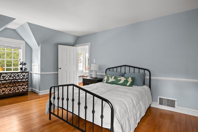 bedroom with lofted ceiling and wood-type flooring