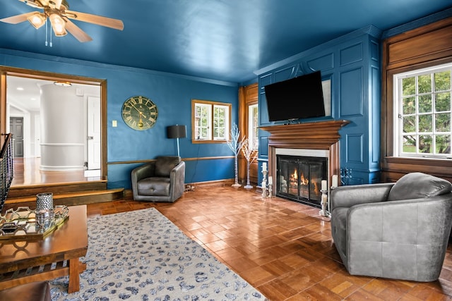 living room featuring crown molding and ceiling fan