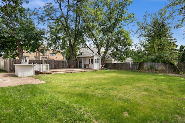 view of yard featuring a storage unit and a deck