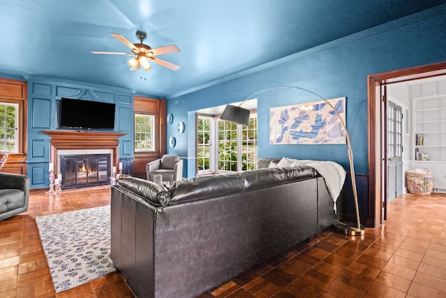 living room featuring ceiling fan, crown molding, and plenty of natural light