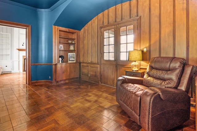 living area with built in features and wooden walls