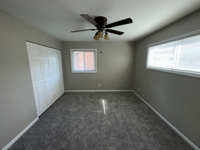 unfurnished bedroom with multiple windows, ceiling fan, and carpet floors