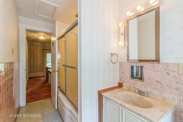 bathroom with shower / bath combination with glass door, vanity, tile walls, and tile patterned flooring