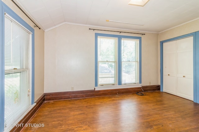 unfurnished bedroom featuring vaulted ceiling, a closet, crown molding, and dark hardwood / wood-style flooring