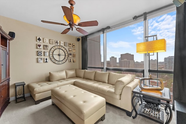 carpeted living room with a healthy amount of sunlight, floor to ceiling windows, and ceiling fan