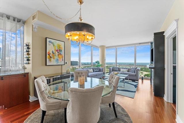 dining area featuring an inviting chandelier, dark hardwood / wood-style floors, and expansive windows