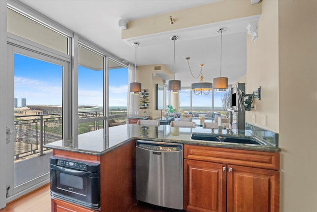 kitchen with pendant lighting, sink, stainless steel dishwasher, black oven, and light hardwood / wood-style floors