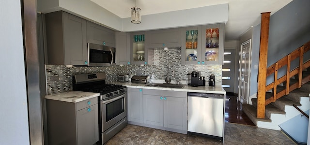 kitchen featuring dark wood-type flooring, stainless steel appliances, decorative backsplash, gray cabinets, and sink