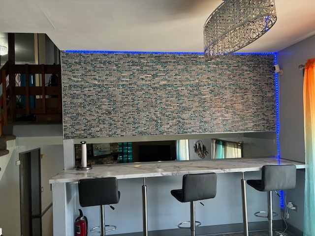 bar featuring tile walls and light stone countertops