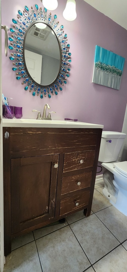 bathroom featuring tile patterned floors, vanity, and toilet