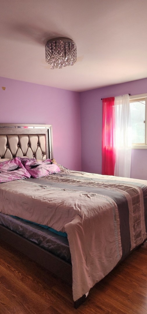 bedroom with dark hardwood / wood-style flooring