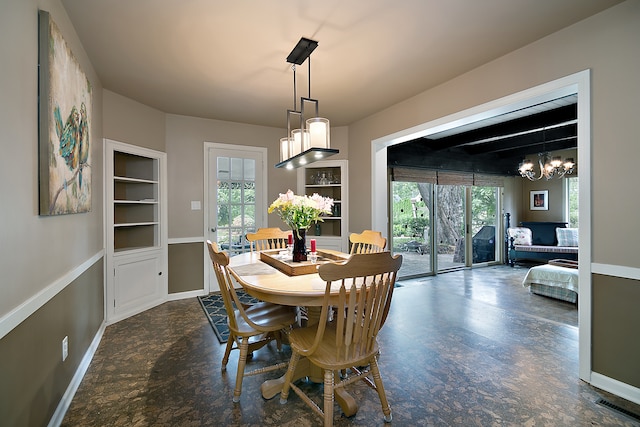 dining space featuring built in shelves and an inviting chandelier