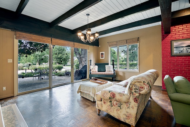 living room featuring parquet floors, an inviting chandelier, and beam ceiling