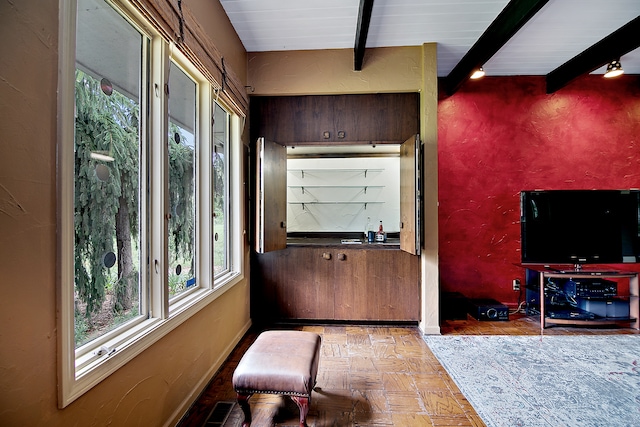 interior space featuring light parquet flooring and beamed ceiling