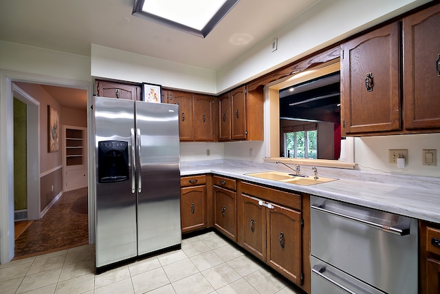 kitchen featuring light tile patterned floors, stainless steel appliances, and sink