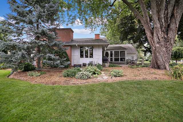 back of house with a sunroom and a yard