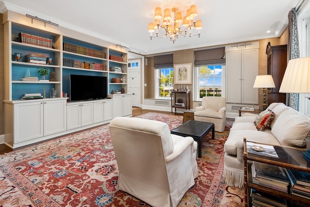 living room with an inviting chandelier, hardwood / wood-style floors, and ornamental molding