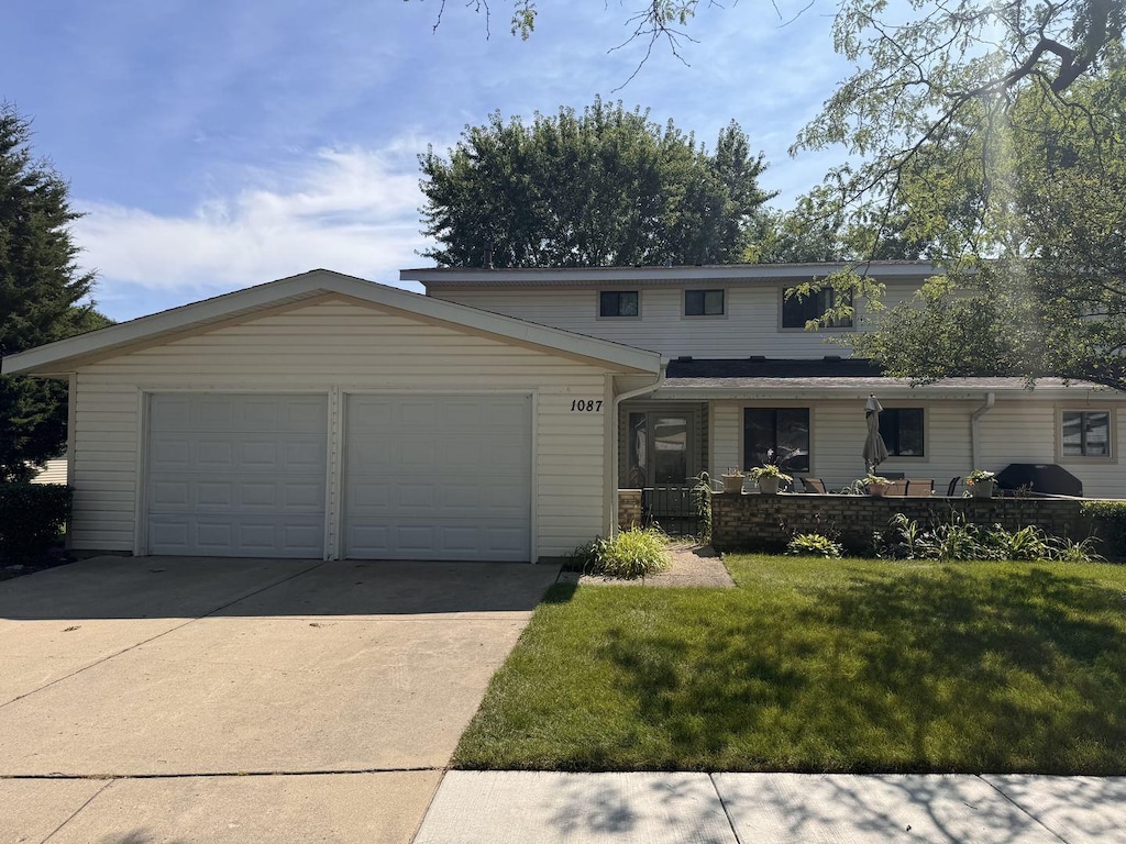 1087 Mohegan Ln, Schaumburg, IL 60193 - view of front of property featuring driveway, an attached garage, and a front lawn