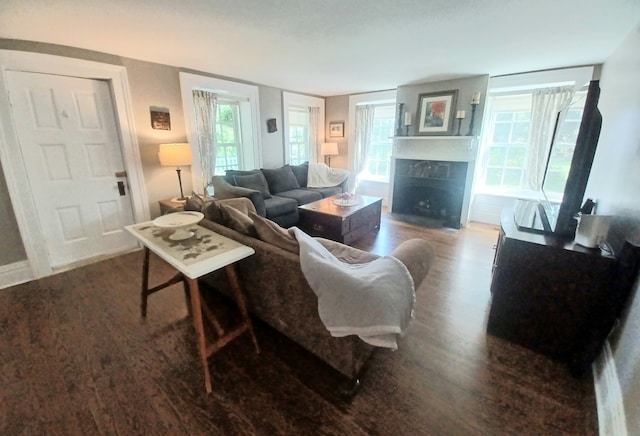 living room with a tile fireplace and hardwood / wood-style floors