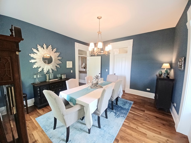 dining room with hardwood / wood-style flooring and a chandelier