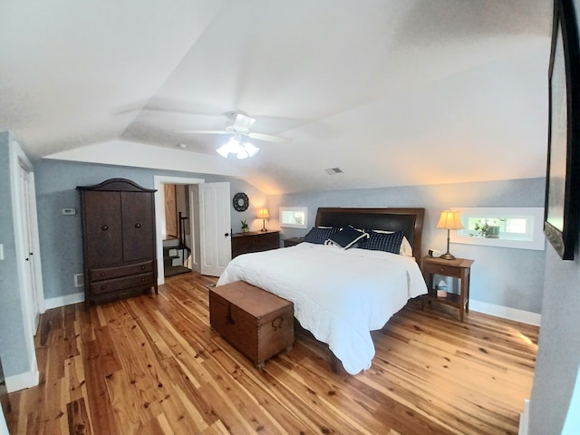 bedroom featuring light wood-type flooring, vaulted ceiling, and ceiling fan