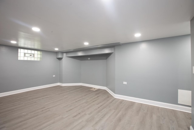 below grade area featuring light wood-style flooring, recessed lighting, and baseboards