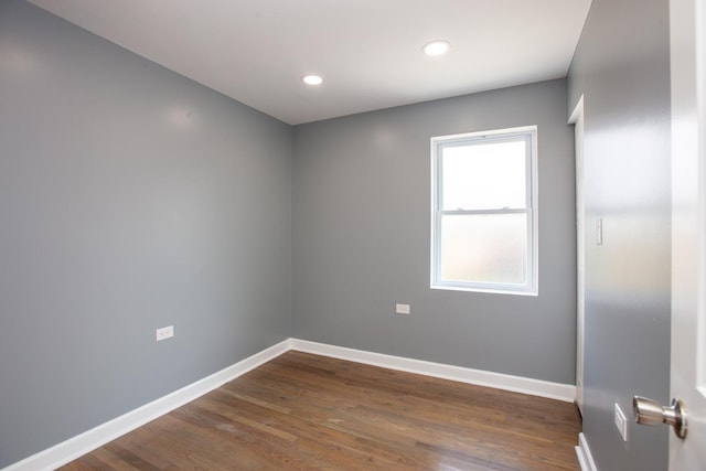 empty room featuring baseboards, dark wood-style flooring, and recessed lighting