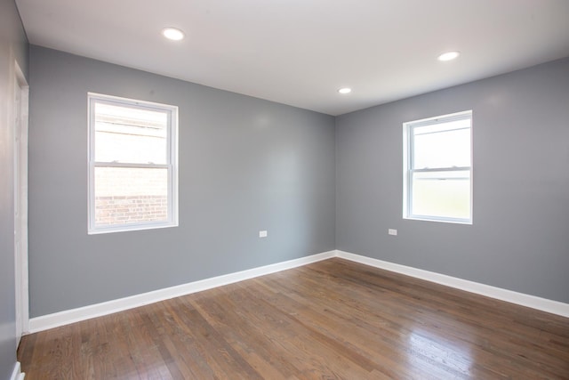 unfurnished room with plenty of natural light, wood finished floors, baseboards, and recessed lighting