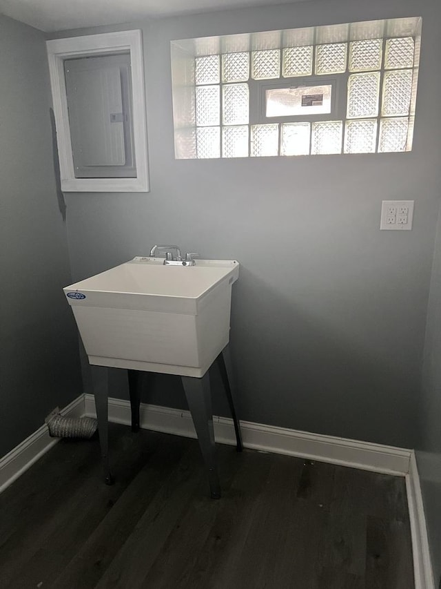 bathroom featuring baseboards, wood finished floors, and electric panel